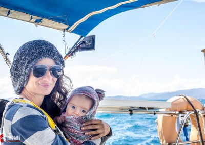 Lady and baby cuddle on a sail boat